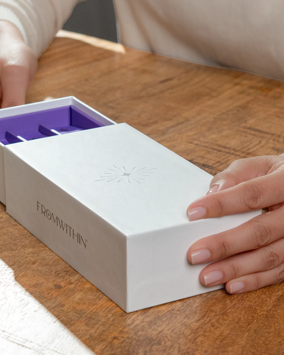 Hands sliding open the FROMWITHIN box